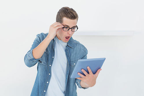 Nerdy20casual20businessman20looking20at20tablet20with20shock20in20his20office